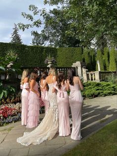 bridesmaids in pink dresses are standing outside