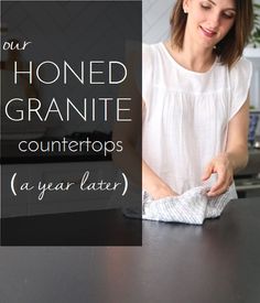 a woman wiping up her kitchen counter top with a paper towel in front of her and the words, your honed granite countertops a year later