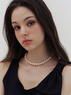 a woman wearing a necklace with pearls on it