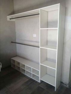 an empty white closet with shelves and drawers