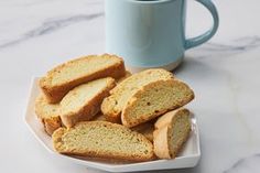 slices of bread on a plate next to a mug