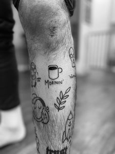 a man with tattoos on his legs and leggings is holding a coffee cup