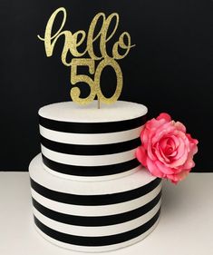 a black and white striped cake with a pink flower on top that says mama to be