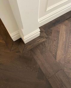 the corner of a room with wood flooring and white trimmings on it