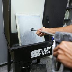 a man is using a drill to fix the screen on an easel in his workshop