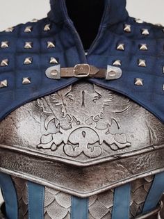 a close up of a man's armor with metal rivets on it