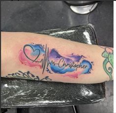 a person with a heart and heartbeat tattoo on their arm