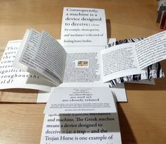 several pieces of paper folded in the shape of a cross on top of a wooden table