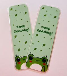 two bookmarks with frog faces and words reading keep reading on them, sitting next to each other