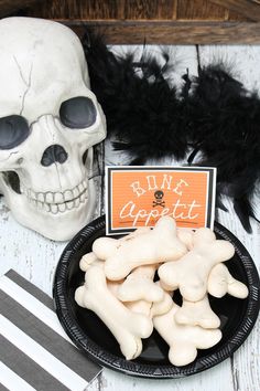 there is a plate with bones on it next to a skull and a sign that says ring appetizer