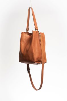 Made with smooth vegetable tanned leather dyed with natural pigmentsrespecting the environment.The Lago is an unlined tote featuring a top handle that can be hand held or used on the shoulder. It also comes with an adjustable and detachable long and slim leather shoulder strap. It has a central compartment with a zipper, and is held shut by a sturdy snap closure.Handcrafted in Argentina by artisans in small batches, with every detail taken care of.Dust bag included for proper storage. Leather Hobo Bag With Detachable Handle For Work, Cognac Shoulder Bag For Work, Cognac Shoulder Bag With Handle Drop For Work, Cognac Shoulder Bag With Adjustable Strap For Work, Leather Backpack With Detachable Handle For On-the-go, Leather Bucket Bag With Leather Lining For On-the-go, Versatile Leather Bucket Bag With Leather Lining, Cognac Leather Bucket Bag For Work, Everyday Cognac Bucket Bag With Detachable Strap