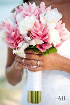 a bride holding a bouquet of pink and white flowers