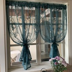 the window is decorated with blue sheer curtains and bowknots, along with flowers