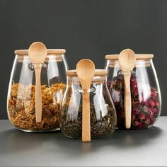 three glass jars with wooden spoons in them