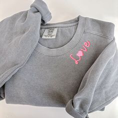 This comfort colors sweatshirt will not disappoint! These sweatshirts are a unisex fit and made from 80% cotton and 20% polyester. They come in the prettiest shades and feature 'Love' in a pretty two tone red/pink script font.  Please wash on gentle cycle and dry on low.  If you don't see the color you are looking for please send me a message. If you would like a different font or design I would be happy to help! Please include thread color at checkout Crew Neck Sweatshirt With Embroidered Graphics For Loungewear, Custom Embroidery Relaxed Fit Crew Neck Sweatshirt, Relaxed Fit Sweatshirt With Custom Embroidery And Crew Neck, Embroidered Crew Sweatshirt For Loungewear, Custom Embroidered Crew Neck Sweatshirt In Relaxed Fit, Custom Embroidery Relaxed Fit Sweatshirt For Loungewear, Relaxed Fit Crew Neck Sweatshirt With Custom Embroidery, Casual Sweatshirt With Custom Embroidery Relaxed Fit, Relaxed Fit Sweatshirt With Embroidered Graphics For Loungewear