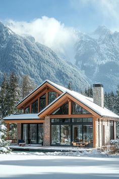 a house in the snow with mountains in the backgroung and trees on either side