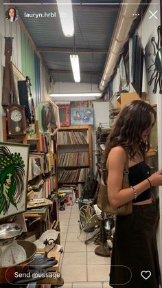 a woman standing in a room filled with lots of books