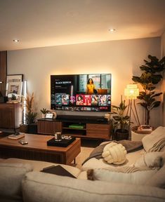 a living room filled with furniture and a flat screen tv on top of a wooden table