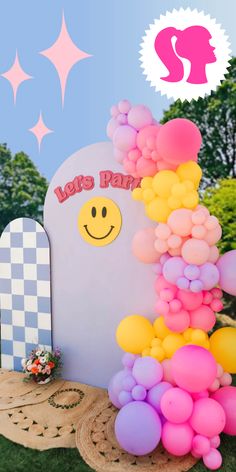 a bunch of balloons that are in front of a sign with a smiley face on it