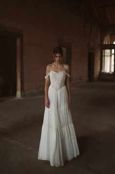 a woman in a white dress standing in an empty room