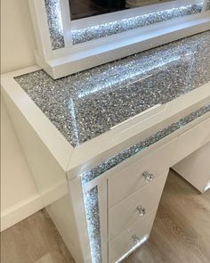 a white vanity with silver glitter on it