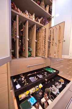 an organized closet with jewelry and bracelets on display in the center, including necklaces