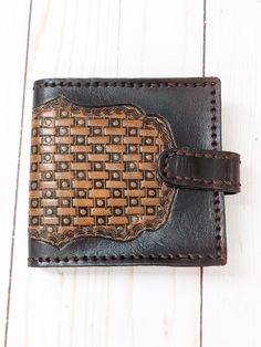 This classic styled tooled leather wallet has a dotted basket-weave pattern in coffee brown centered in a dark brown background. Brown hand stitched construction. Chrome plated snap on the strap closure adds security. Dark brown mission grain leather interior. One pocket with a window for your ID and 4 additional credit card pockets. Long pocket for bills and a change pocket with chrome plated clasp closure. This one has semi finished edges that are dyed and smooth but do show layering of the le Brown Artisan Wallet With Coin Pocket, Artisan Brown Wallets With Coin Pocket, Brown Leather-lined Rectangular Wallet, Brown Hand Tooled Trifold Wallet, Rectangular Leather Wallet With Snap Closure, Brown Embossed Wallets For Daily Use, Brown Rectangular Trifold Wallet With Leather Lining, Vintage Brown Wallets With Leather Lining, Brown Trifold Wallet With Leather Lining