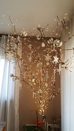 a christmas tree decorated with lights and snowflakes in the corner of a room