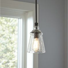 a light fixture hanging from a ceiling in front of a window