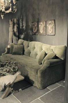 a living room filled with furniture and paintings on the wall next to a coffee table