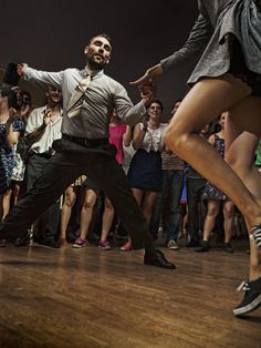 a man and woman dancing in front of a crowd