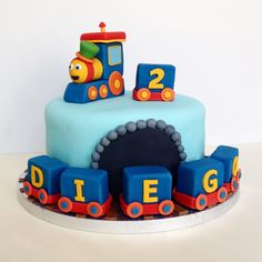 a thomas the train birthday cake with blue frosting and fondant decorations on top