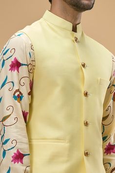 Lemon yellow sleeveless solid bundi crafted in cotton silk. Paired with a bloom vine print kurta and a white pant. - Aza Fashions Fitted Cotton Nehru Jacket For Spring, Festive Yellow Nehru Jacket For Spring, Sleeveless Cotton Nehru Jacket For Spring, Luxury Spring Digital Print Kurta, Yellow Nehru Jacket For Spring Festivals, Yellow Nehru Jacket For Festive Spring Occasions, Spring Multicolor V-neck Kurta, Yellow Slub Silk Kurta With Pallu Detail, Semi-stitched Yellow Kurta With Floral Embroidery