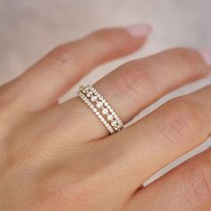 a woman's hand with a diamond ring on top of her finger and the bottom half