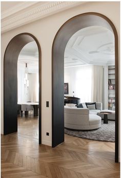 an open living room with wood floors and arched doorways