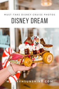 a person holding up a toy car made out of candy and marshmallows with the words must - take disney cruise photos