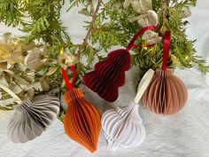 three origami ornaments hanging from a christmas tree