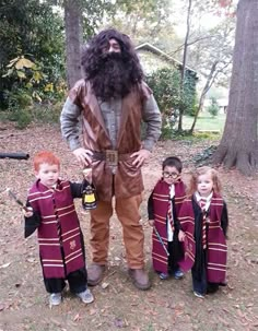 a man with long hair and beard standing next to three children