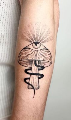 a man's arm with a mushroom tattoo on it