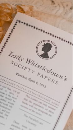 the lady whistleton's society papers are laying on a lace tablecloth,