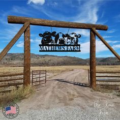 a wooden gate with a sign that says maxwells farm on it and cows in the background