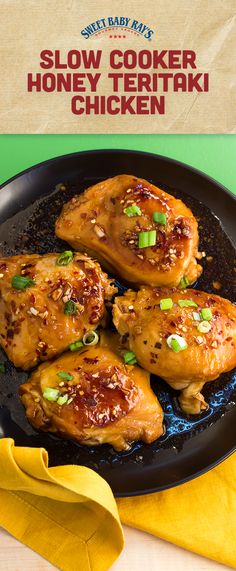 chicken wings with sesame seeds and green onions on a black plate