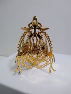 a gold brooch sitting on top of a white surface