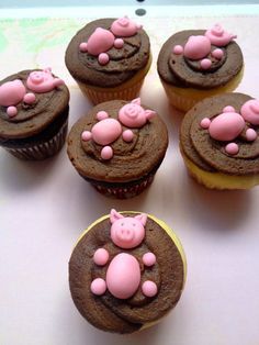 six cupcakes with pink pigs on them sitting on a table top next to each other