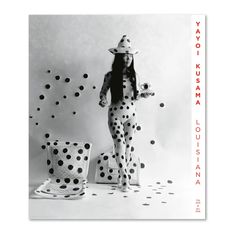 a black and white photo of a woman with polka dots on her body, standing in front of a wall