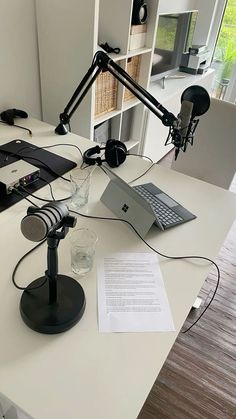 a laptop computer sitting on top of a desk next to a microphone and headphones