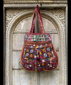 About bag  Indo-gypsy fusion, everyday use hand bag made from Banjara fabrics sourced from Vintage tribal costumes of regions of Rajastan and Gujarat. These are embellished with light catching coins, and intricate bead work tassels. Size - length 15 inches/ width 21 inches Company details:  Company name: Houseoftextile  Contact number: +919784447473  Email id: houseoftextile77@gmail.com  Shipping & custom : Delivery through one of the finest service providers : Skyway, Fedex, UPS  And DHL. Any l Bohemian Potli Bag With Mirror Work For Festive Occasions, Handmade Festival Hobo Tote Bag, Traditional Tote Shoulder Bag With Handwork, Traditional Shoulder Bag With Handwork In Tote Shape, Bohemian Multicolor Potli Bag For Festive Occasions, Traditional Handwork Tote Shoulder Bag, Bohemian Multicolor Potli Bag For Festive Season, Traditional Shoulder Bag Tote With Handwork, Traditional Shoulder Tote Bag With Handwork