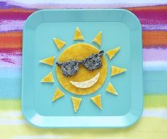 a blue plate topped with an orange slice and sunglasses