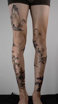 the legs and ankles of a man with tattoos on his body are covered in black ink