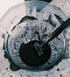 a dirty glass bowl with a spoon in it